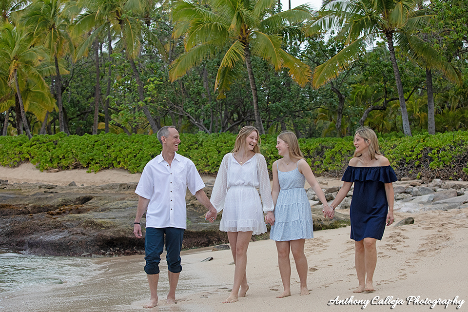 Family holding hands walking on the sands of Secret Beach,, KoOlina Oahu Hawaii
